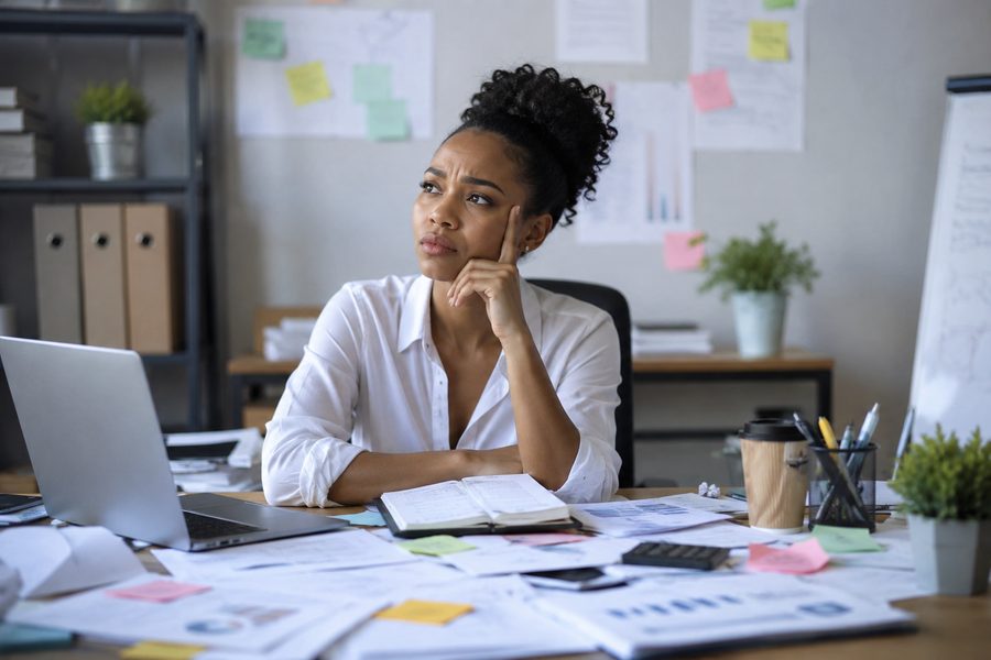 Someone at a cluttered desk, the kind of day-to-day mess Ife helps you get on top of